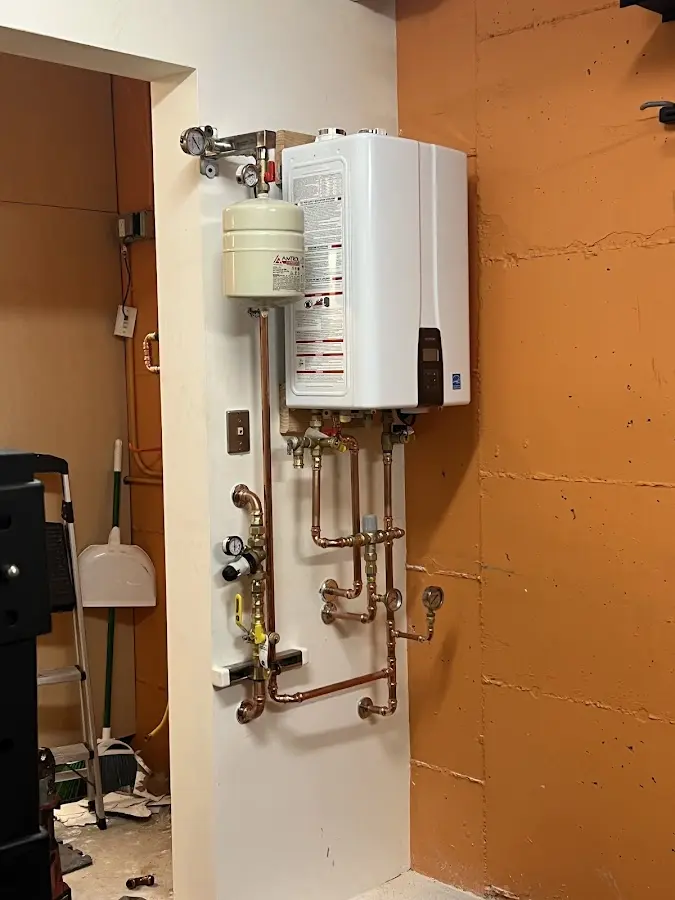 Plumbing technician inspecting water heater connections in Colleyville